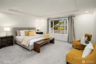 The fully remodeled spa-inspired primary suite is a true retreat, offering generous proportions, soft neutral tones, and a beautiful window with serene views of the mature landscaping beyond.