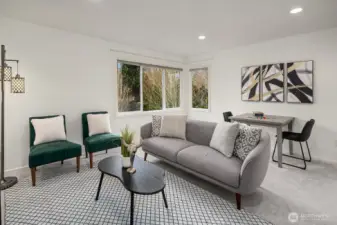 A bright and versatile upper level bedroom offers generous space, large windows with lush green views, and a stylish neutral palette — perfect for guests, family, or a secondary sitting room.