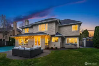 This stunning Buchan home shines at dusk, with warm interior lighting, elegant architecture, and beautifully manicured landscaping creating an impressive and welcoming presence from the street.