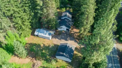 Aerial view of the home, garge, and shop situated on a couple acres