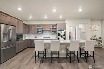 Chef's kitchen with quartz countertops, huge island and stainless steel appliances.