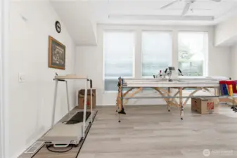 Great room with longarm quilting machine. The Laminate flooring flows throughout the home for ease of cleaning.