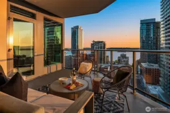 A large corner balcony extends from both the living room and the primary suite, offering a front-row seat to stunning sunsets over Elliott Bay and the Olympic Mountains.