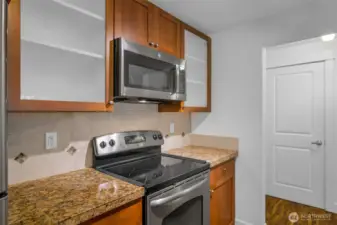The kitchen has an amazing workspace. Enjoy shaker cabinets, new microwave, glass cooktop and tons of cabinet space. Granite counters and 1 compartment sink.  Tile accents make the space feel modern and clean up is a breeze.