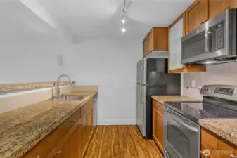 The kitchen has an amazing workspace. Enjoy shaker cabinets, new microwave, glass cooktop and tons of cabinet space. Granite counters and 1 compartment sink.  Tile accents make the space feel modern and clean up is a breeze.
