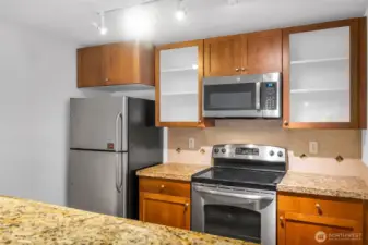 The kitchen has an amazing workspace. Enjoy shaker cabinets, new microwave, glass cooktop and tons of cabinet space. Granite counters and 1 compartment sink.  Tile accents make the space feel modern and clean up is a breeze.