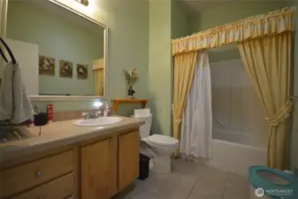Primary bathroom showcasing the dual sink, toilet, and soaking tub.