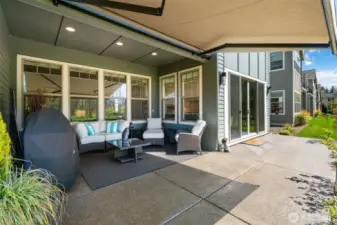 Delightful back patio has 12' sliding glass doors access the full width, extended concrete patio with a remote operated awning and a drop screen
