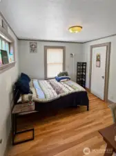 Tucked away for privacy and peace, this bedroom combines vintage details with a warm, inviting atmosphere. Hardwood floors and original trim speak to the home’s classic craftsmanship, while soft natural light from dual windows makes the space feel cheerful and restful. Whether it’s your primary retreat or a welcoming guest room, this space is full of quiet charm.