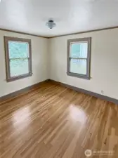 Bright, open, and full of potential — this secondary bedroom is a blank canvas for your vision. Original hardwood floors and vintage window trim keep the home’s 1920s charm intact, while dual windows invite natural light throughout the day. Whether you need a guest room, office, or creative space, this room is ready to make it yours.