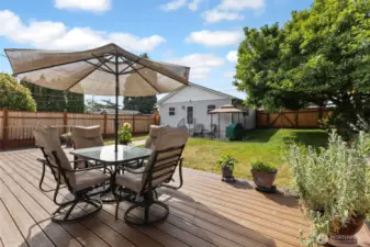 Another view of the large deck. The backyard is fully fenced with newer fencing. Sit and relax or invite guests over for a BBQ dinner. The grill & gazebo in the background can stay. Patio furniture to go with sellers.