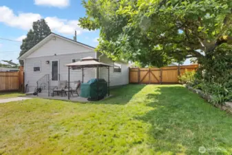 A flat backyard for easy mowing. Alley access to the garage and to the backyard directly--possible RV parking. The landscaping includes some beautiful plants & flowers & this fantastic flowering tree just getting ready to bloom.