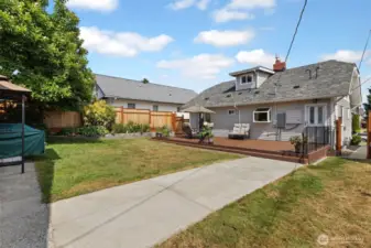 A backyard view back toward the house showing the great low profile deck. Access via the back alley gate for fewer stairs. Gate access to the front yard at the right of photo.