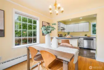 Dining room with sliders to a west-facing front deck and adjoining to a breakfast bar and kitchen.