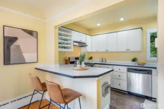 Dining room with sliders to a west-facing front deck and adjoining to a breakfast bar and kitchen.