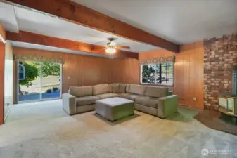 2nd living room with big wood beams, propane stove and back deck.