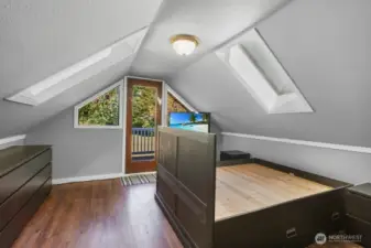 Primary bedroom bedroom upstairs with skylights and Juliet balcony