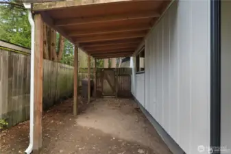 SIDE YARD | Covered space for the lawn mower and yard tools.