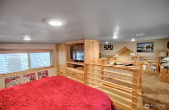 UPSTAIRS LOFT WITH CABINETS AND TV