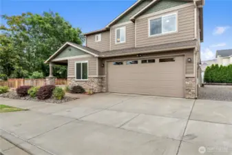 Three-car garage with additional driveway parking and RV space beside it.