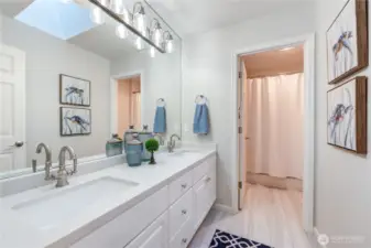 Updated guest bathroom with double sinks, quartz counter top, updated lighting and flooring.