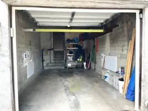 Inside Look of 1-Car Garage with Automatic Door Opener and Code Pad. Stairs from Garage to Basement.