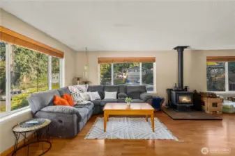 A cozy wood stove adds a second heat source and a touch of rustic charm, complementing the open-concept design. The positioning of both fireplaces enhances comfort and efficiency while leaving plenty of room to reimagine the space for entertaining or extended living arrangements.