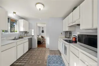 Efficient galley layout with long work surfaces on both sides, abundant cabinetry, and a handy pass-through opening to the adjacent flex room.