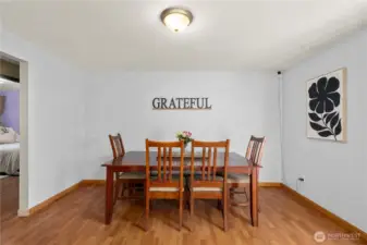 Bright and open dining space connects directly to the kitchen, ideal for hosting meals or creating a casual breakfast nook. Laminate flooring keeps maintenance simple and durable.