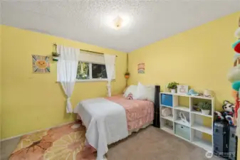 This cheerful upstairs bedroom offers a comfortable layout with a large window framing peaceful yard views. Neutral flooring and simple lines make it easy to personalize, while the cozy size and proximity to the other upper bedrooms make it ideal for children, guests, or an upstairs office.