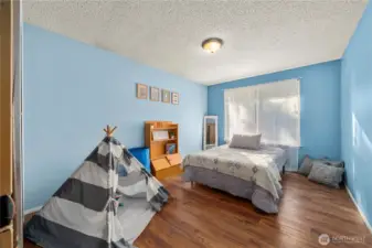 Spacious and bright, this upstairs bedroom features durable laminate flooring and a large window that fills the room with natural light. The generous size makes it versatile enough to serve as a relaxing retreat, guest space, or flex room—ideal for anyone wanting extra comfort and privacy on the upper level.