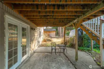Covered patio beneath the deck provides a shaded retreat ideal for relaxing or entertaining. The lower-level French doors offer convenient private access to the finished basement — perfect for guests, hobbies, or multi-generational living.