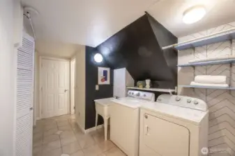 Lower hallway laundry area with convenient laundry sink. Far door leads to the garage.