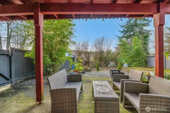 Fenced back yard with paito.