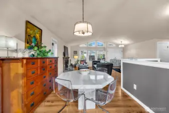 View from the back door looking onto the dinning, open kitchen to the right and living room. Vaulted ceiling and lots of windows open this up.