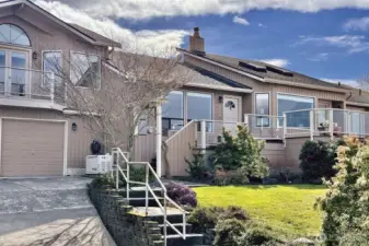 Terraced front yard with mature landscaping & additional parking along the street. Whole house Generac generator (conveys) installed in 2023 & has a 5-YR annual Maintenance package to 2028 (transferable to new owners). Notice all the windows and glass side panels on the deck.