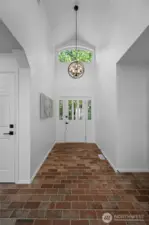Grand entry with soaring ceilings, transom window, and rich brick flooring makes a stunning first impression.    Grand entry with soaring ceilings, transom window, and rich brick flooring makes a stunning first impression.    Grand entry with soaring ceilings, transom window, and rich brick flooring makes a stunning first impression.