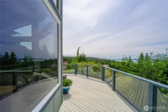 Spacious deck with glass railing- perfect for outdoor dining and soaking in the views.