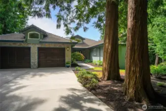 Lush, professionally landscaped grounds provide beauty and privacy, while the attached double car garage offers easy access and ample storage.