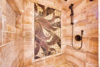 The main floor shower finished in natural Honey Onyx stone and features an imported natural stone mosaic.