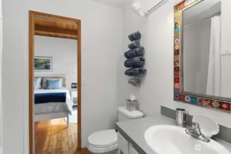 Bathroom with walk-in shower, is conveniently accessible from both the bedroom and kitchen area.