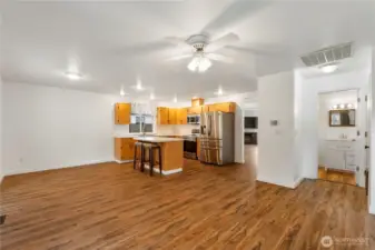Looking back from family room into kitchen half bath and living rooms.  There is all new bright white paint through out home