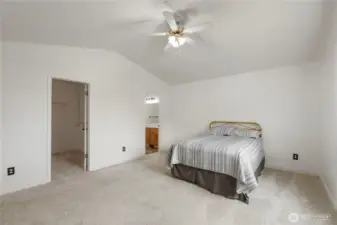 Large primary bedroom view with walk in closet vaulted ceilings and primary bathroom