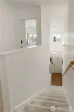 Hall stairs leading to entry way with new paint and carpeting upstairs to keep you warm