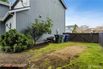 This is side yard view off front of home with double gate big enough for extra cars RVs or all your gardening needs