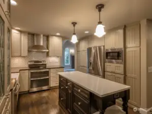 Kitchen with microwave and refrigerator. The island has loads of storage