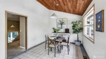 This striking dining room showcases a vaulted rich wood ceiling that beautifully contrasts with the crisp white walls.