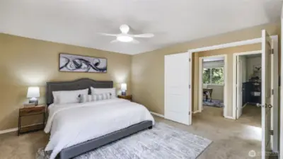 Double doors open into the spacious primary bedroom, complete with a ceiling fan for added comfort