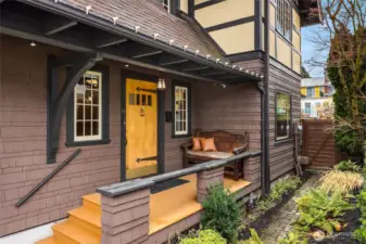 The charming covered entry is so welcoming with it's wood soffits and large wooden porch. Large strap hinges on the front door and the shingled siding is impeccable.