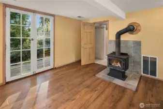 Lower level living room has hardwood floors, a wood burning stove and a bathroom with full shower.